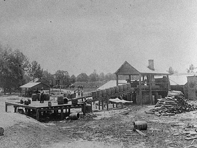 A Thomas County turpentine still produces rosin and turpentine in the early 1900s. Along with other naval stores products, rosin and turpentine were used in the construction and repair of sea vessels. © Courtesy of Georgia Archives, Vanishing Georgia Collection